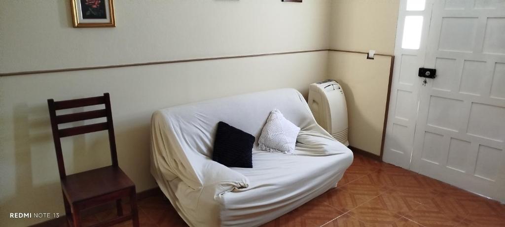 - un canapé blanc avec deux oreillers dans l'établissement Residencial Soares, à Espargos