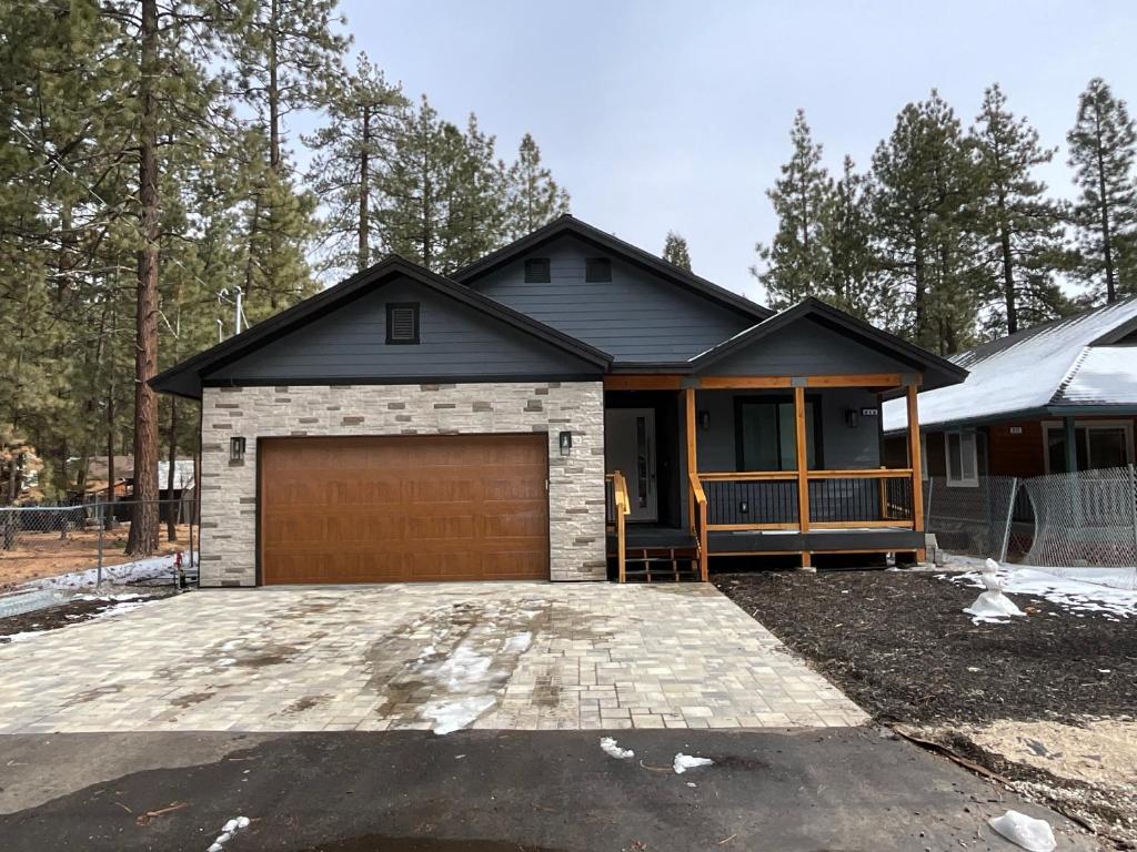 ein Haus mit einer Garage davor in der Unterkunft Bear Port Cabin Getaway in Big Bear City Airport