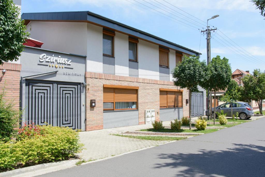 a building with a sign on the front of it at Szíriusz Apartmanház in Gyula