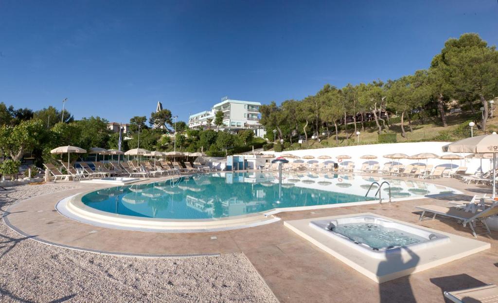 努馬納的住宿－Hotel Eden Gigli，度假村内的大型游泳池配有椅子和遮阳伞