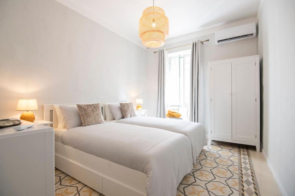 a white bedroom with a white bed and a window at Maltese Charm - Seaside Stay - Table Soccer in St. Julianʼs