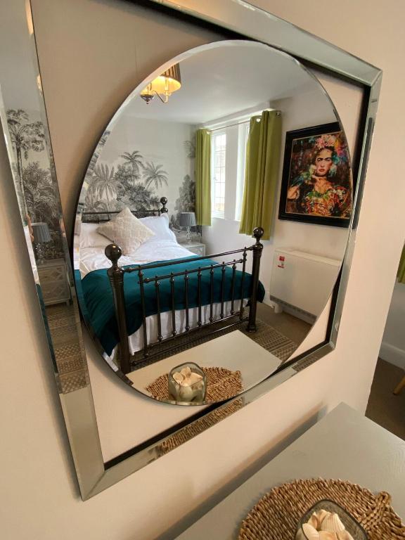 a bedroom with a bed and a mirror on the wall at Gallery Apartment in Stratford-upon-Avon