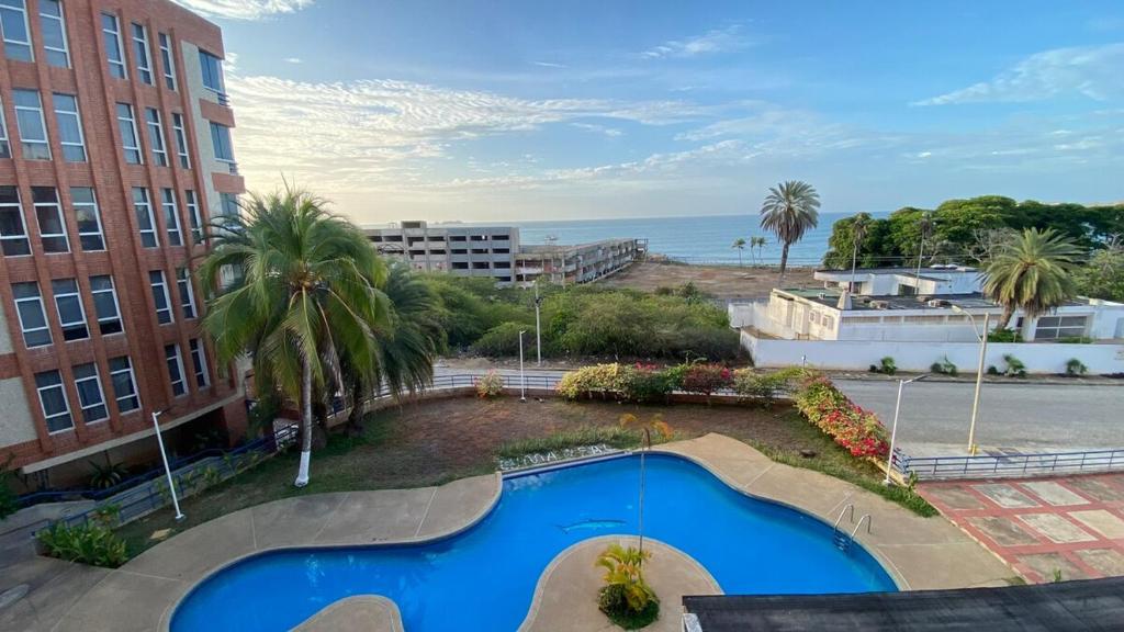 a view of a swimming pool with the ocean in the background at Alquiler Apartamento Vacacional con Vista al Mar, Isla de Margarita in Porlamar