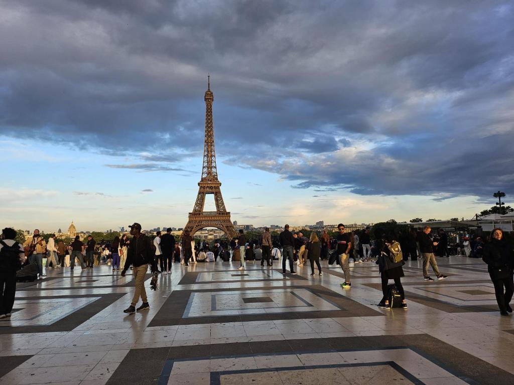 Une foule de gens marchant devant la tour de l'eiffel dans l'établissement charming apartment close to Emily's spots in Paris, à Paris