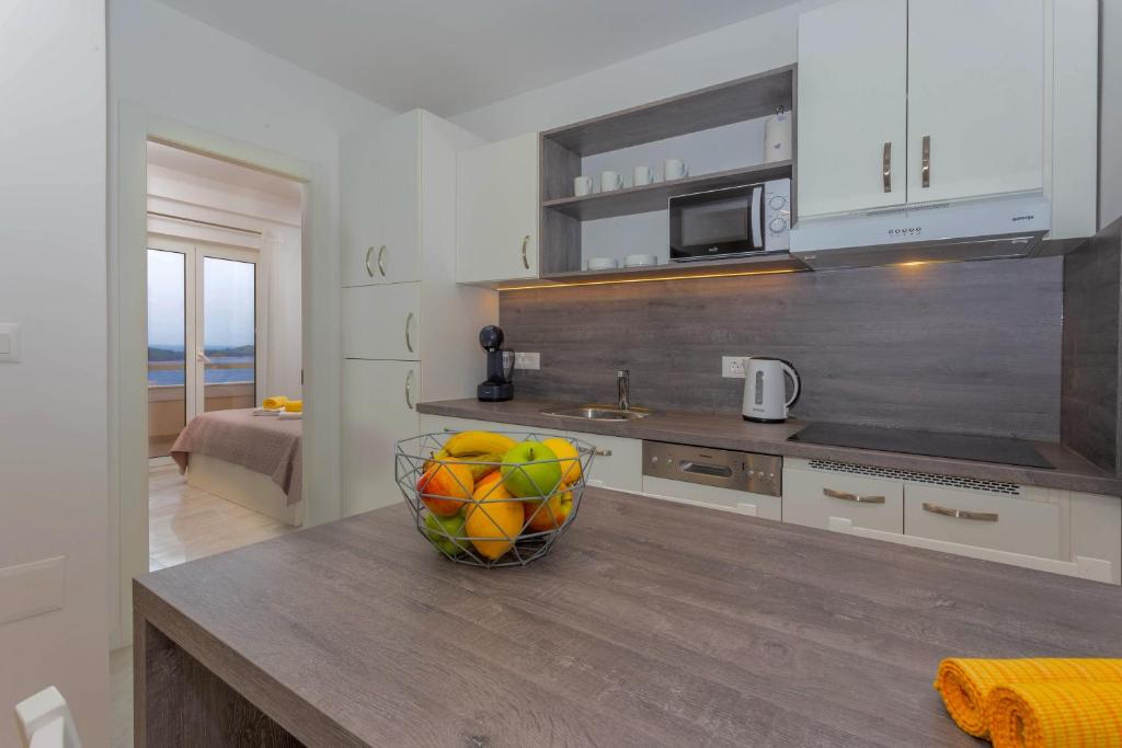 a kitchen with a bowl of fruit on a counter at Apartments Tatjana Dominis in Hvar