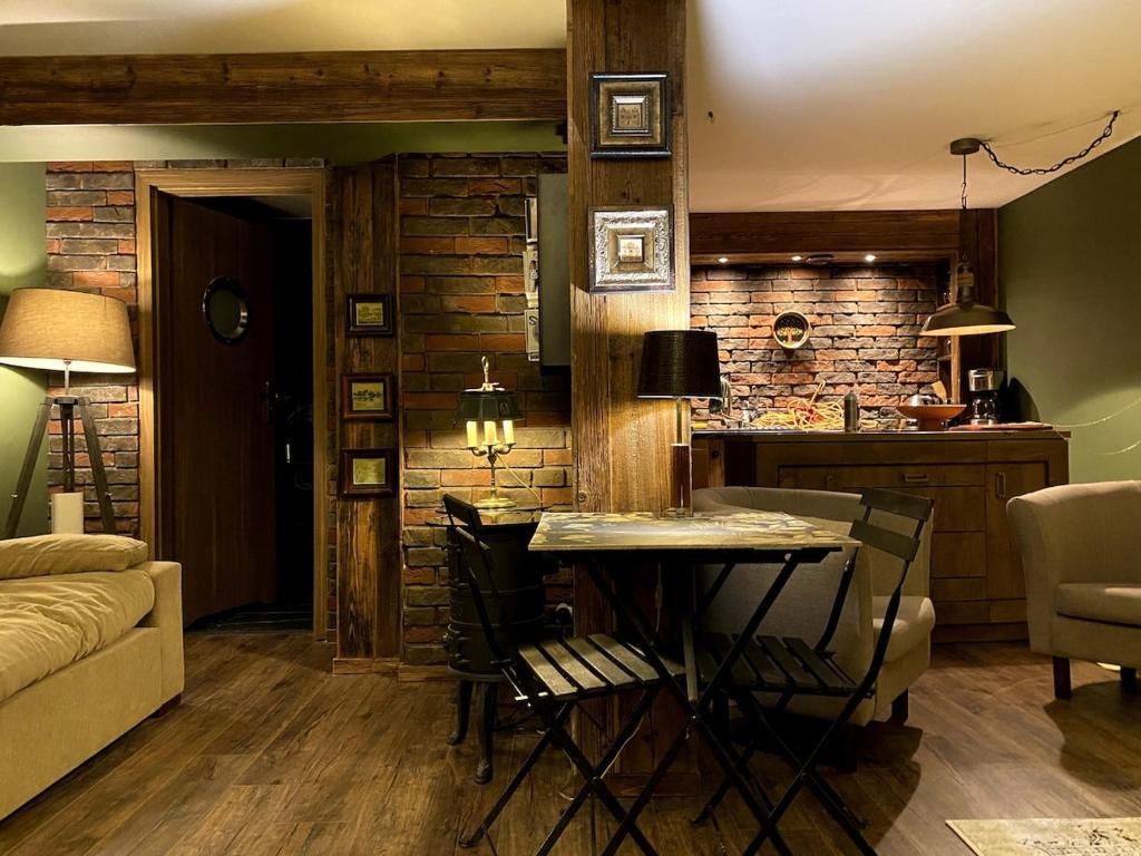 Una sala de estar con una mesa y una cocina. en Jaros, en Szczecinowo