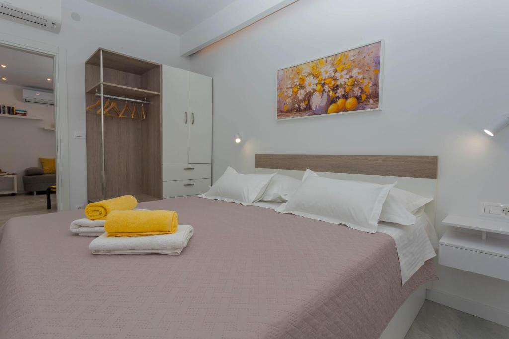 a bedroom with a large bed with towels on it at Apartments Tatjana Dominis in Hvar