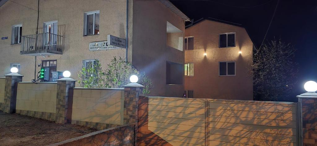 a fence in front of a building at night at Luxor Inn & Suites in Chernivtsi
