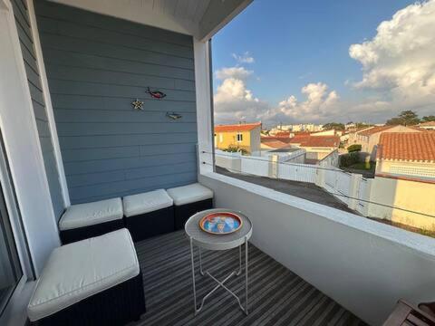 d'un balcon avec une chaise, une table et une fenêtre. dans l'établissement La cabane du pêcheur, à La Celle-sous-Gouzon