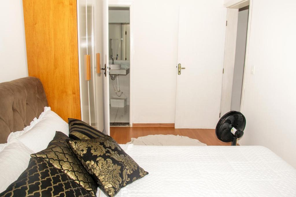 a bedroom with a bed and a bathroom at Ap 3 Ouro Pret com piscina aquecimento solar e churrasqueira in Ouro Preto