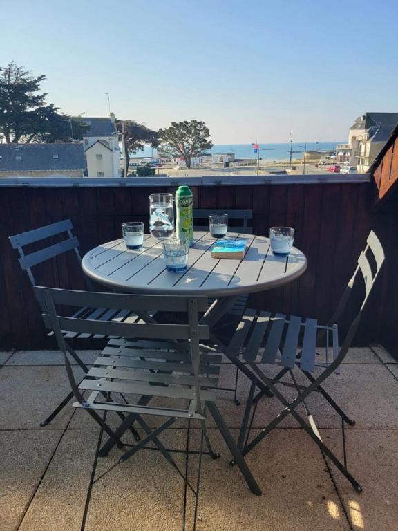 une table et des chaises avec vue sur la plage dans l'établissement La Cormorane, à Carnac