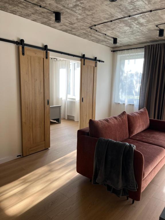 a living room with a couch and two sliding doors at Apartament nad Nilem in Kolbuszowa