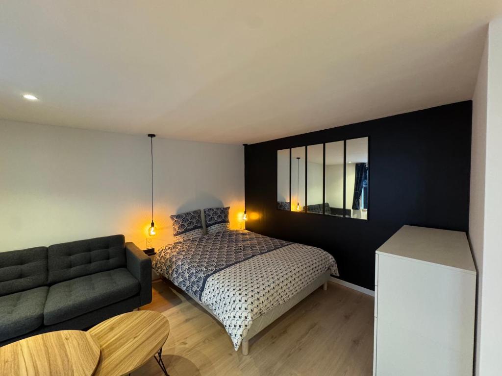 une chambre avec un lit et un canapé dans l'établissement Grand Studio - Au Faubourg - Strasbourg Centre, à Strasbourg