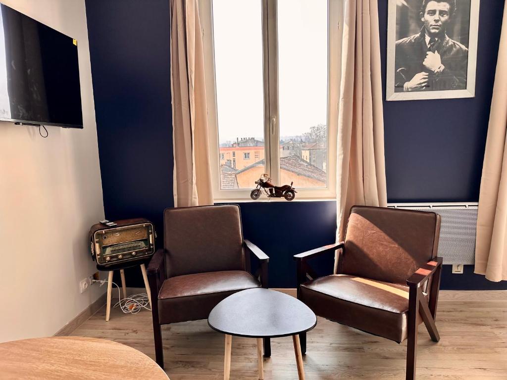 une chambre avec deux chaises, une table et une fenêtre dans l'établissement Le studio Vintage du centre ville - Proche coeur historique, à Bergerac