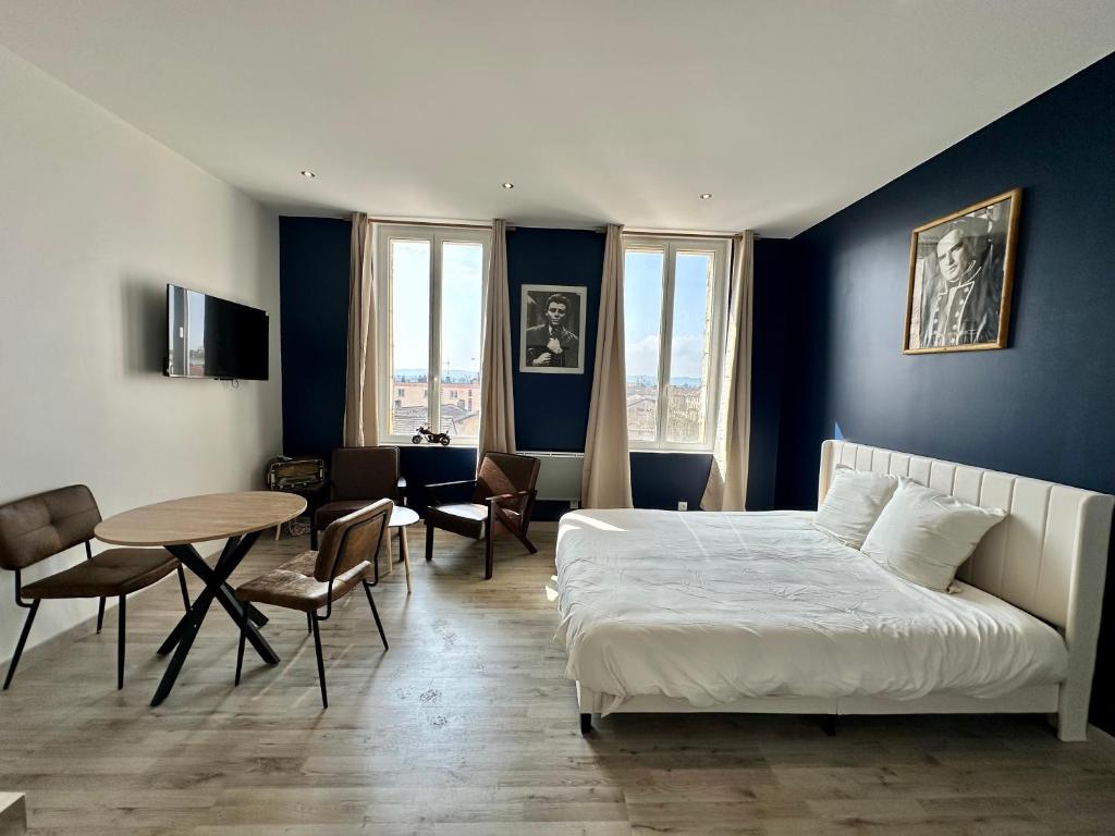 a bedroom with a bed and a table and chairs at Le studio Vintage du centre ville - Proche coeur historique in Bergerac