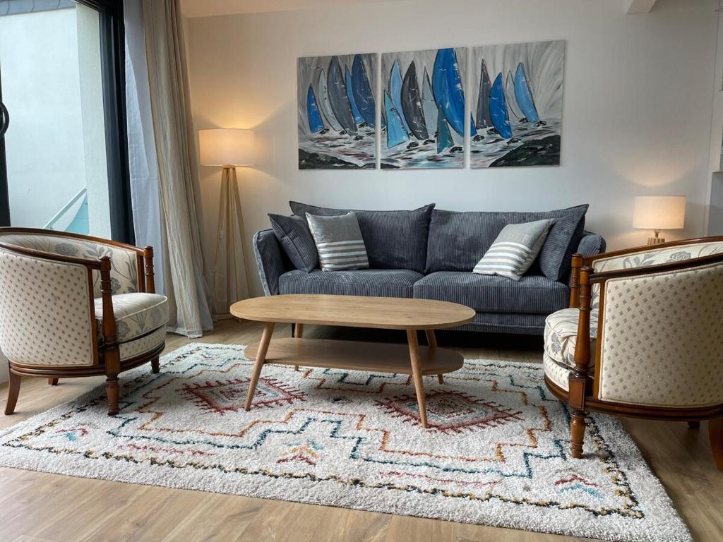 a living room with a couch and a coffee table at Plein centre Auray - Grand duplex 2 chambres avec terrasse ensoleillée in Auray