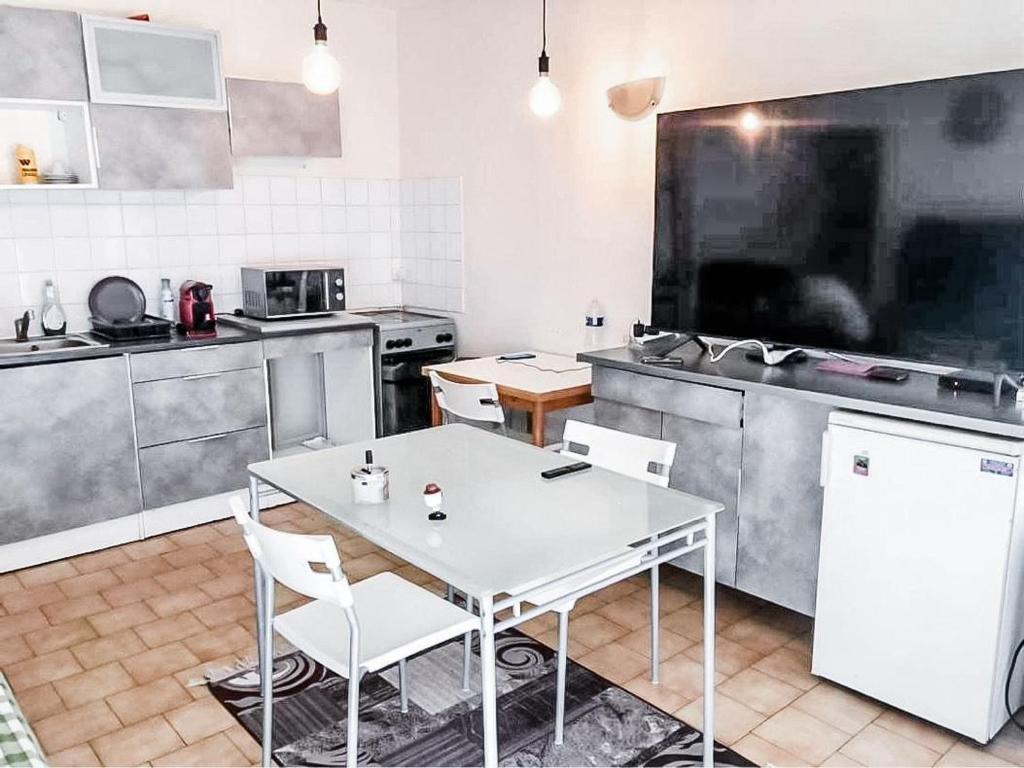 une cuisine avec une table et des chaises dans une cuisine dans l'établissement Charmant appartement à Puteaux, à Puteaux