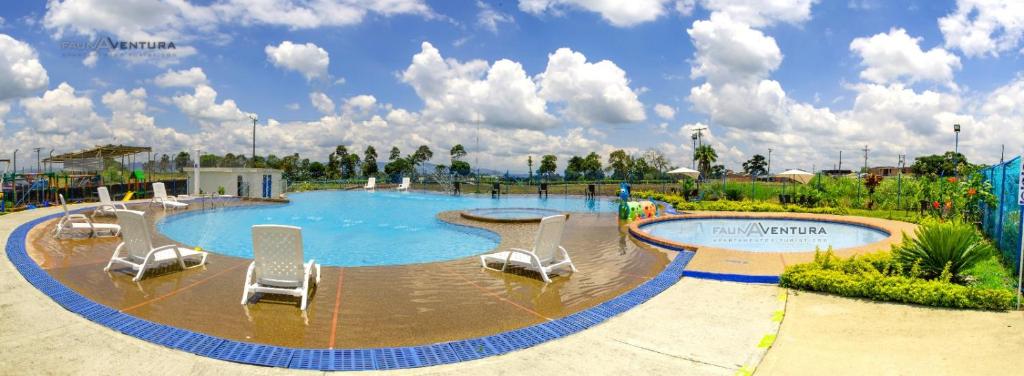 a large swimming pool with chairs in a park at Espectacular Apartahotel full equipado 5min del Parque del Café in Montenegro