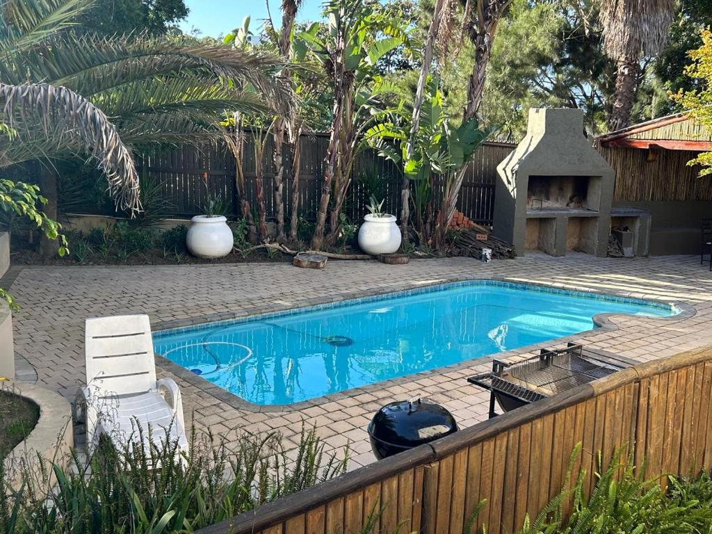 a small swimming pool in a yard with a fence at Mansion De La Luna in Plettenberg Bay