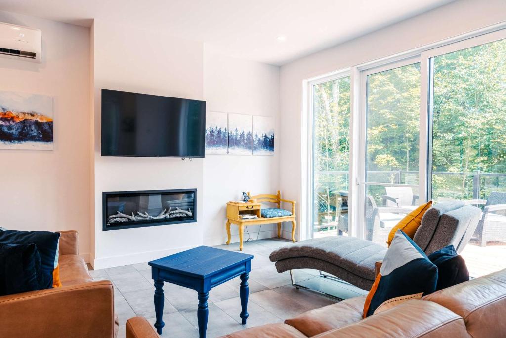 a living room with a couch and a fireplace at Le Yéti de Tremblant in La Conception