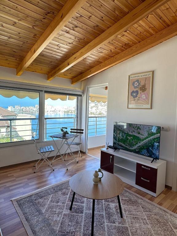 a living room with a television and a table at Spacious Lovely Apartment in Sarandë