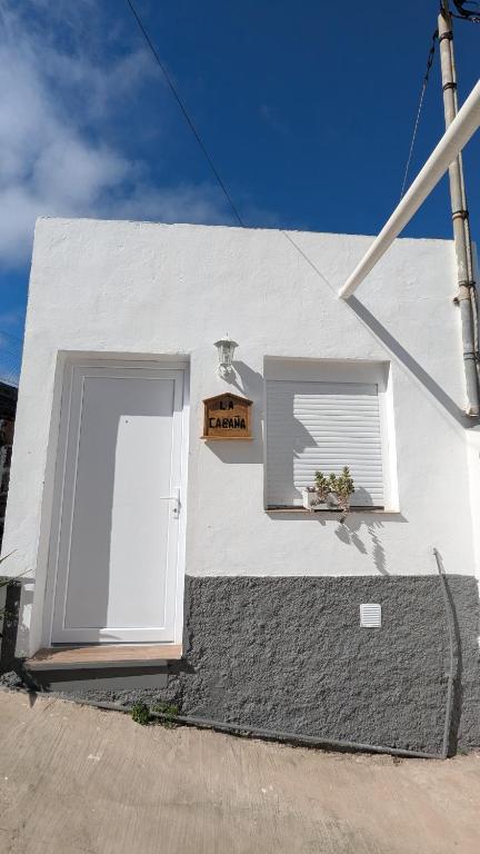 a white house with a door and a window at La Cabaña Estudio pequeño in Fasnia