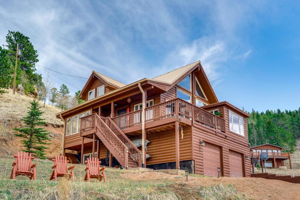 a wooden house with four chairs in front of it at Lakefront Divide Cabin with Game Room! in Woodland Park
