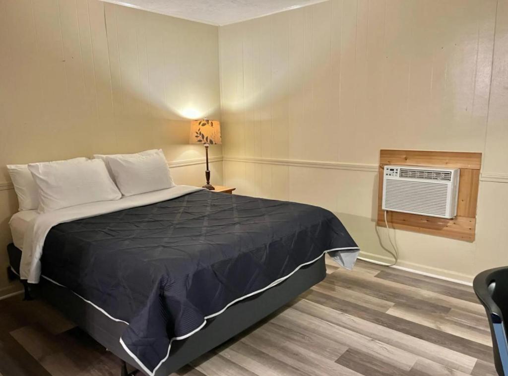 a bedroom with a bed and a air conditioner at Harper Motel in Harper