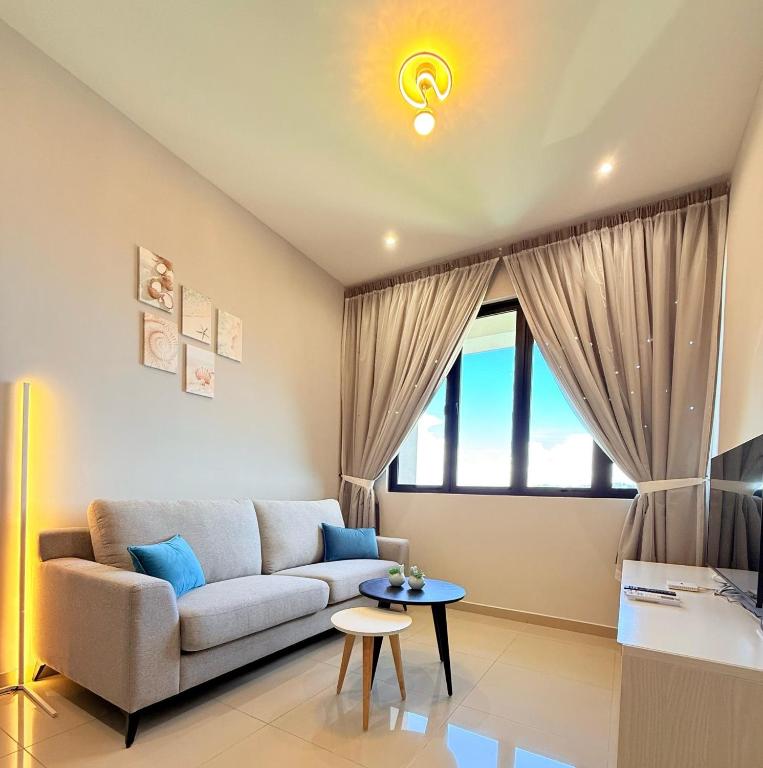 a living room with a couch and a table at Iconic Regency Service Residences - Xin's Home in Bayan Lepas