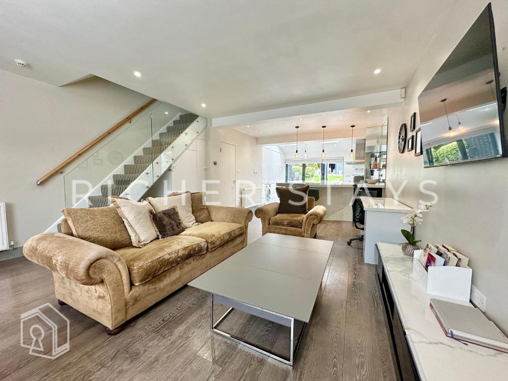 a living room with a couch and a table at Premium 3BR House, French Doors and Private Garden in Borehamwood