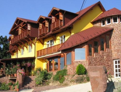 una gran casa amarilla con techo marrón en Prima Porta Vendeghaz en Balatonalmádi