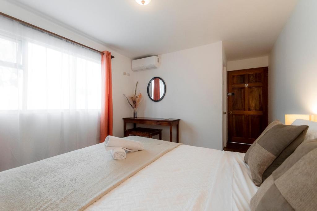 a bedroom with a large white bed with a window at Habitacion doble delux - Casa Esmeralda in San José