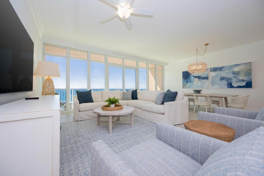 a living room with blue couches and a tv at Phoenix Gulf Towers 906 condo in Gulf Shores