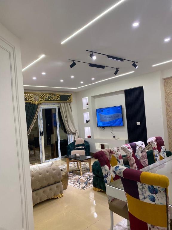 a living room with two couches and a tv at Wealthy in Madīnat ash Shurūq