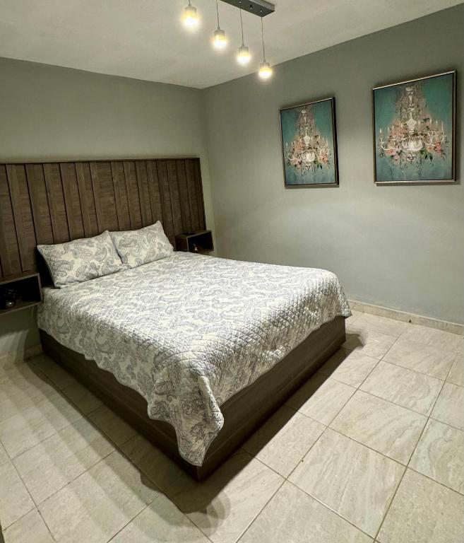 a bedroom with a large bed and two pictures on the wall at Estancias Nava #1 in San Antonio