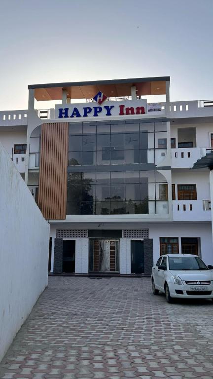a white car parked in front of a happy inn at Happy Inn in Faizābād