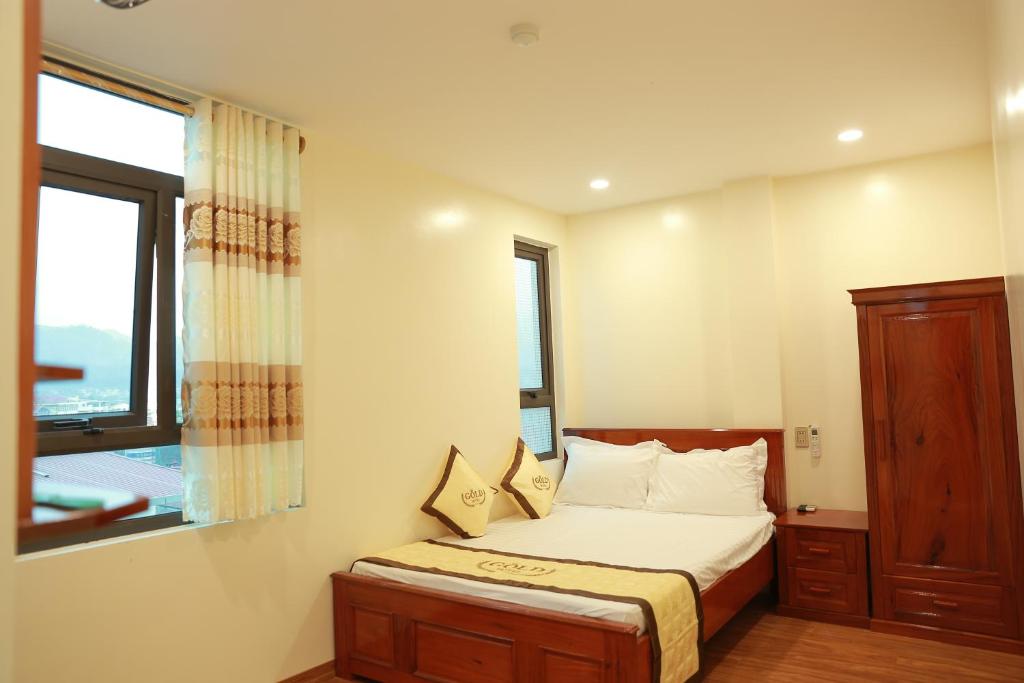 a small bedroom with a bed and a window at Gold Hotel in Bản Gùm