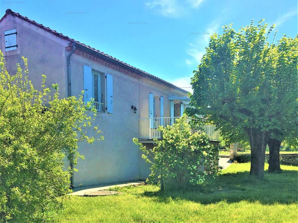 une maison avec un arbre devant dans l'établissement Maison cosy à Ruoms avec terrasse et animaux admis - FR-1-697-37, à Ruoms