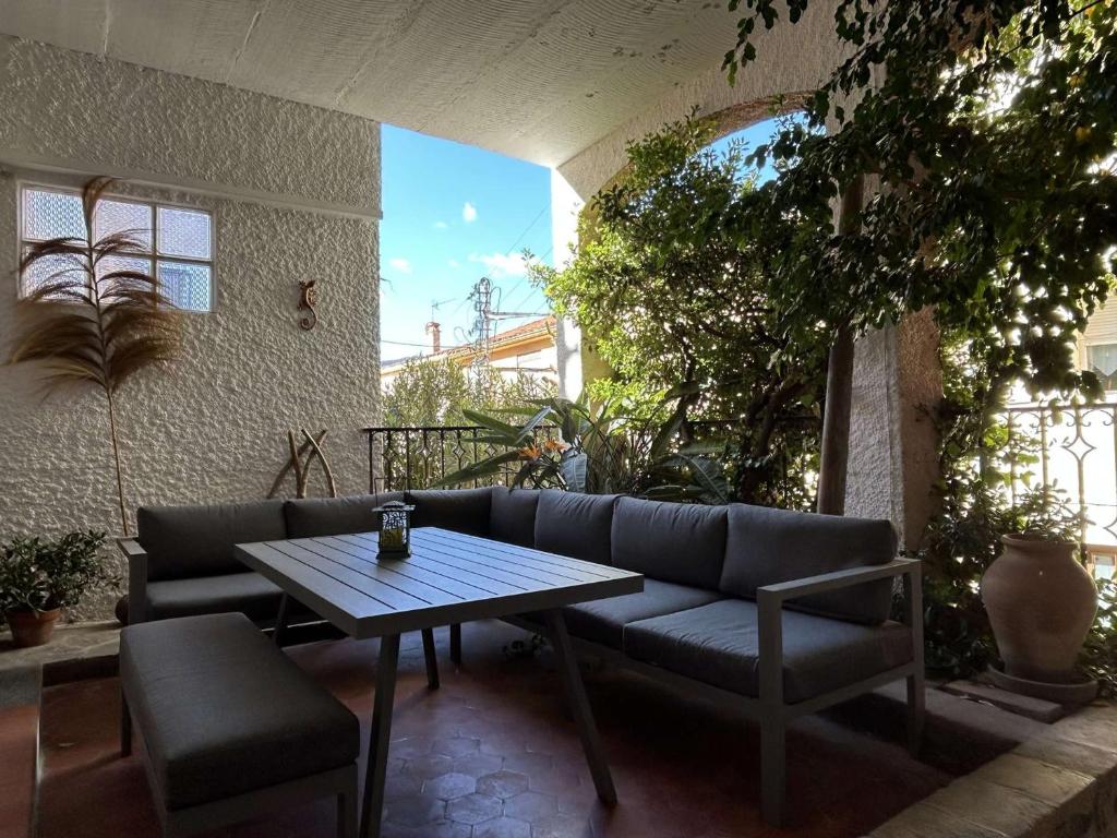 d'un canapé et d'une table sur une terrasse. dans l'établissement Appartement 2 pièces moderne avec patio à Banyuls-sur-Mer - FR-1-225C-166, à Banyuls-sur-Mer
