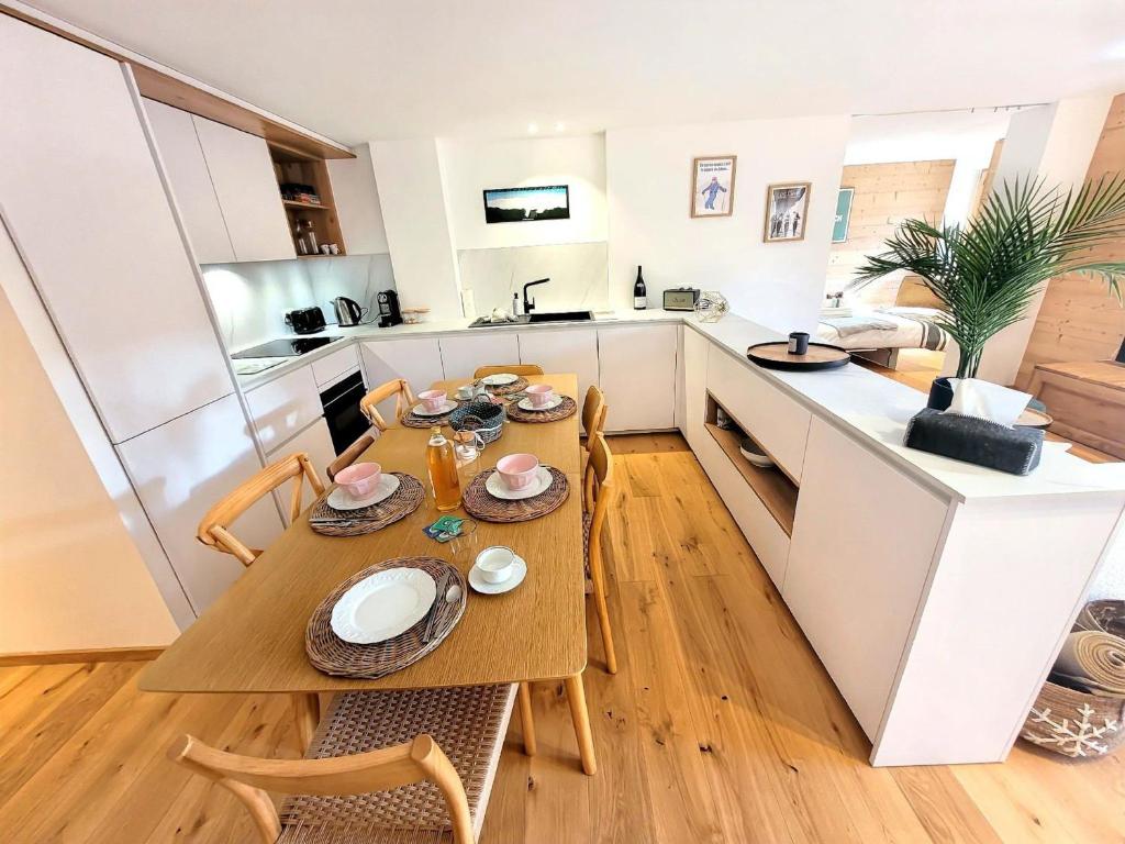 une cuisine et une salle à manger avec une table et des chaises dans l'établissement Confort élé gant avec terrasse, idéal pour famille - FR-1-598-187, aux Gets