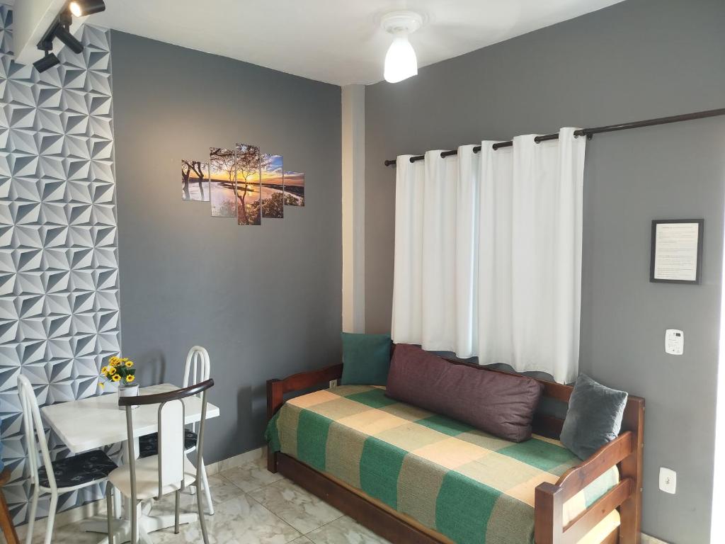 カボ・フリオにあるFlat Solife 1 Cabo Frio-Búziosのベッドとテーブルのある小さな寝室