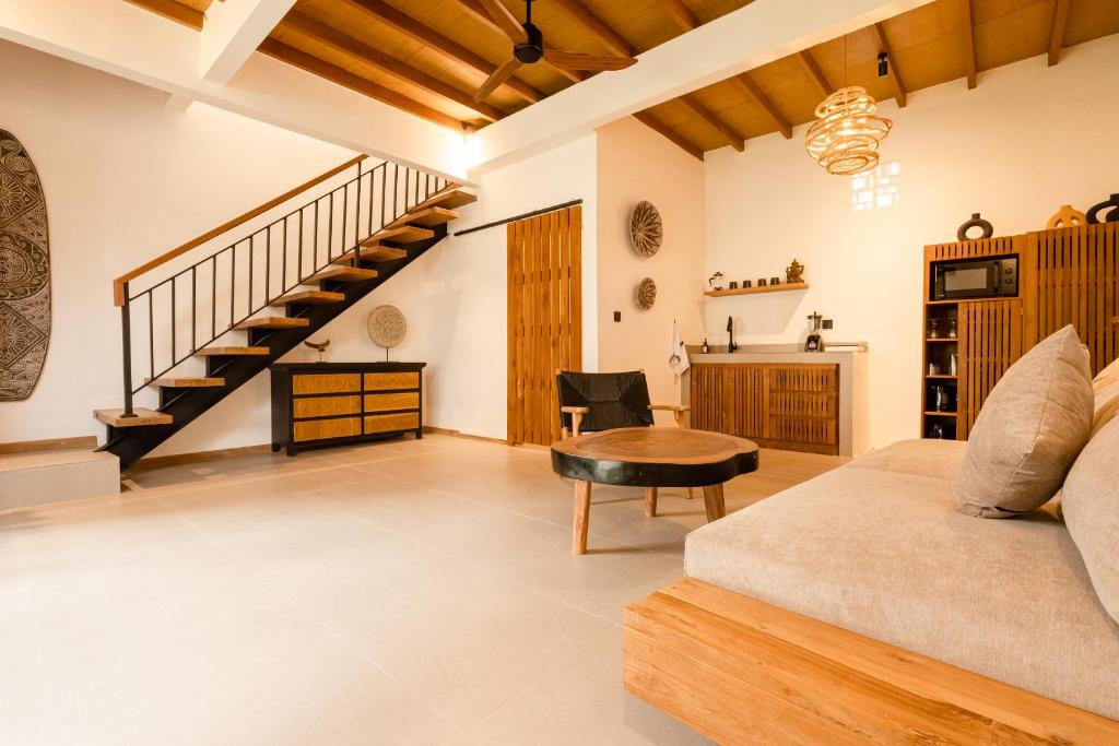 a living room with a couch and a staircase at Brand-New Loft Balangan Village in Badung