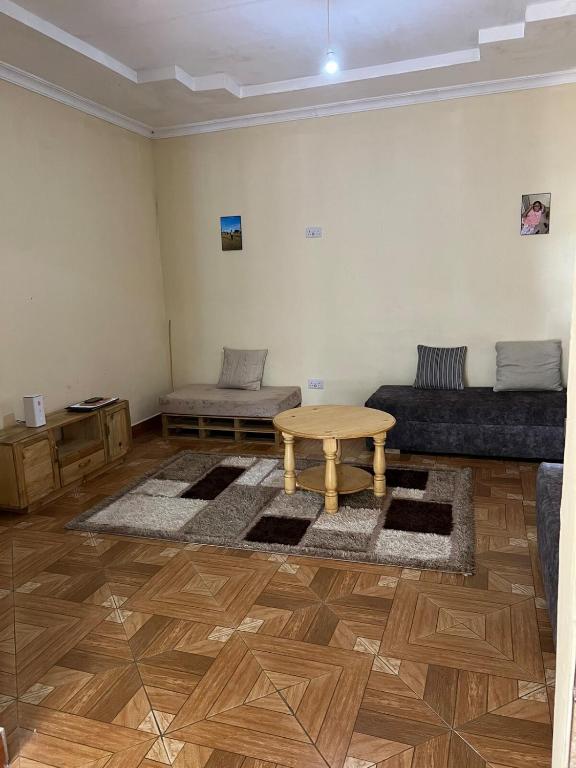 a living room with a table and a couch at 'La Maison' 2 bedroom house in Arusha in Arusha