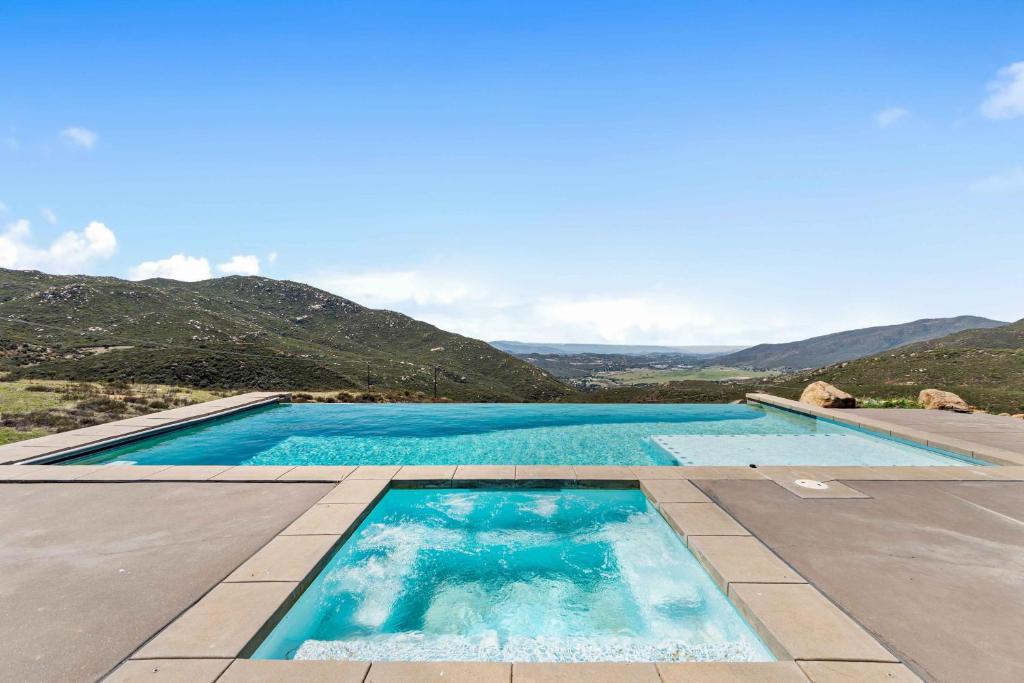 ein Pool mit blauem Wasser und Bergen im Hintergrund in der Unterkunft nmc in Descanso