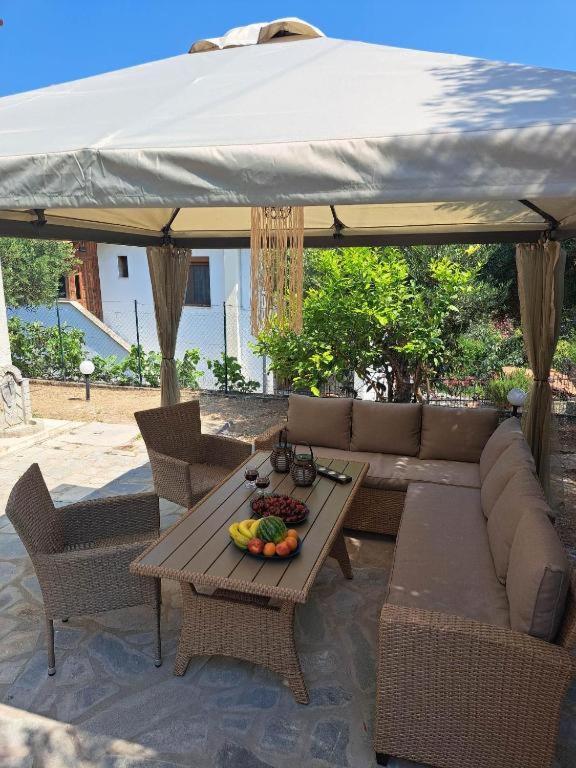 a patio with a couch and a table with fruit on it at Vintage villa in Paleo Tsifliki