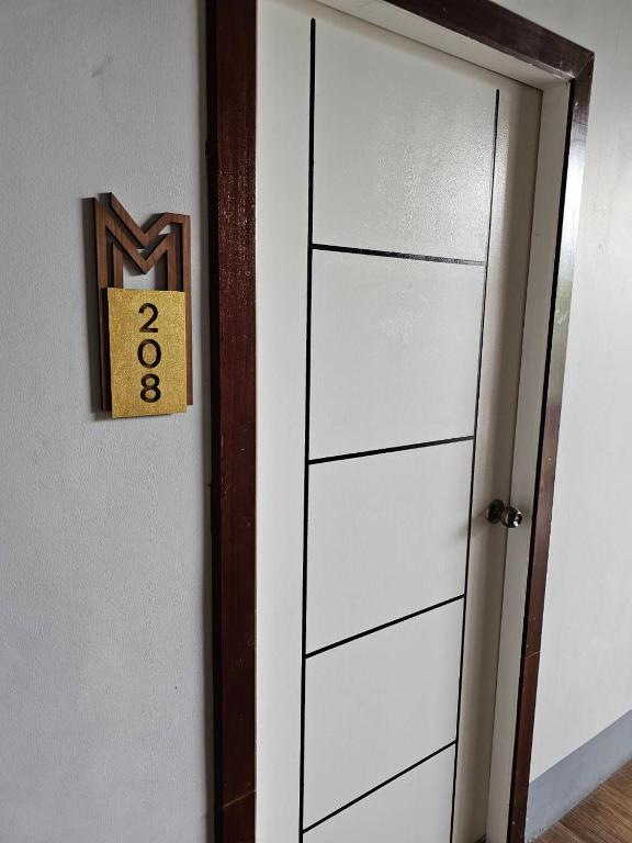a white door with a sign on it next to it at Madugu Service Apartment in Chiang Mai
