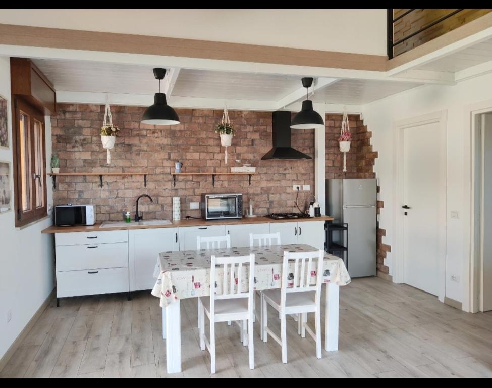 a kitchen with a table and chairs and a brick wall at villino Andrea in Anzio