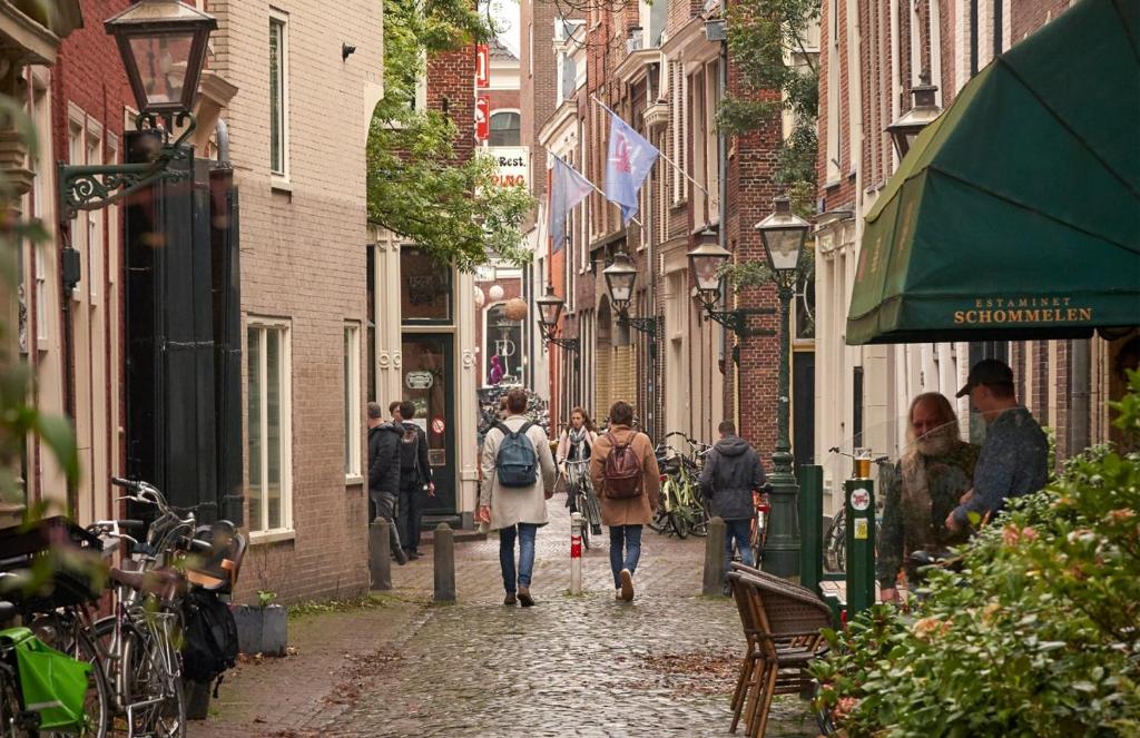 a group of people walking down a cobblestone street at WS77 B&B Apartment in Leiden
