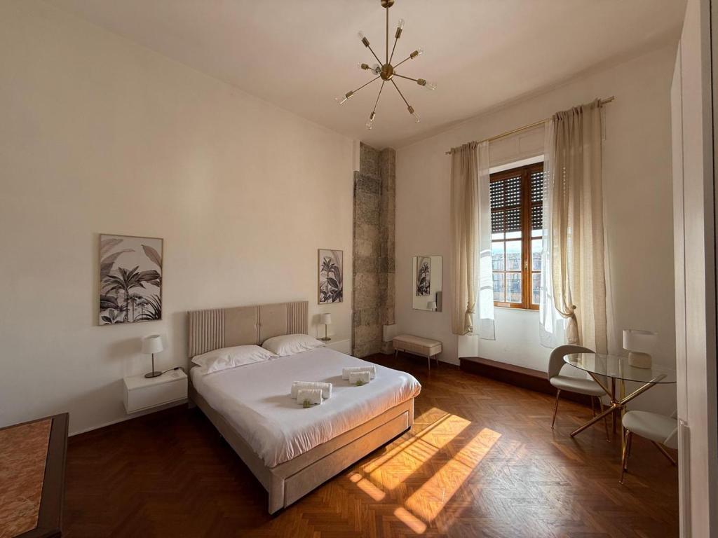 a bedroom with a large white bed and a table at Pisa Paradiso Nice View in Pisa
