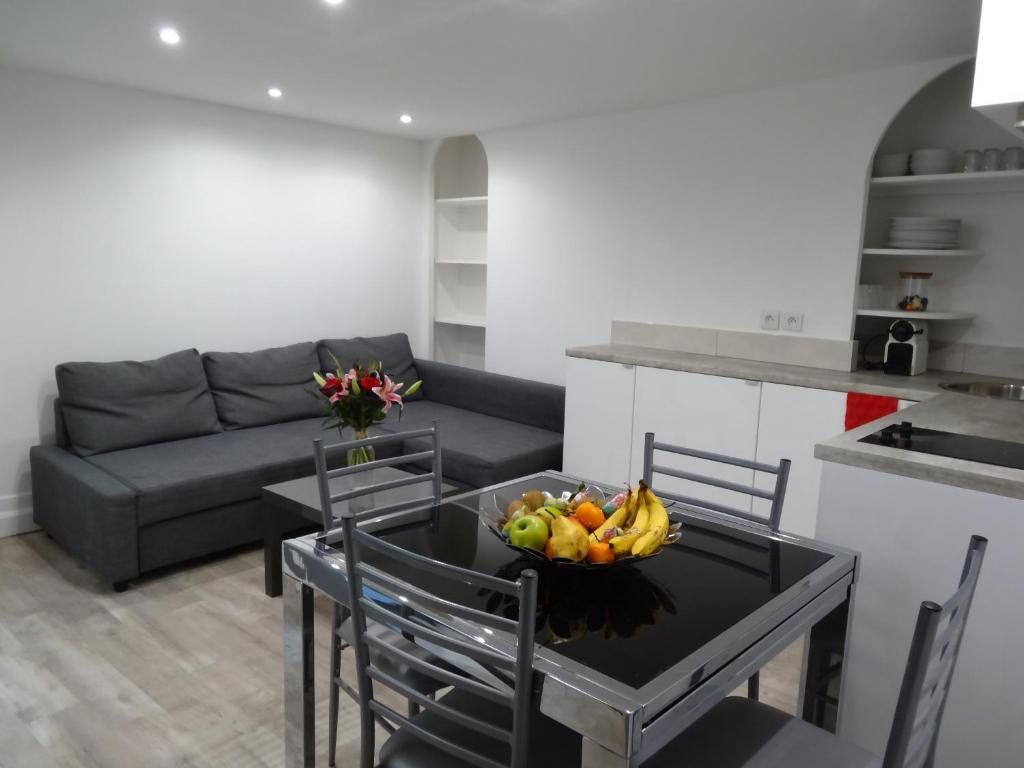- un salon avec une table et une corbeille de fruits dans l'établissement Practical Lodging near Le Louvre, à Paris